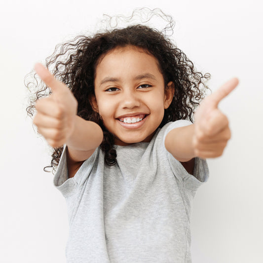 Smiling girl with her arms out giving two thumbs up sign